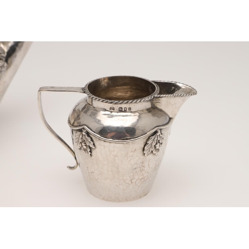 143 - AN ARTS & CRAFTS THREE PIECE SILVER TEA SET, BY AMY SANDHEIM. tapering circular form, with corded bo... 