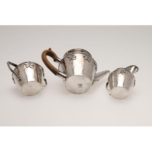 143 - AN ARTS & CRAFTS THREE PIECE SILVER TEA SET, BY AMY SANDHEIM. tapering circular form, with corded bo... 