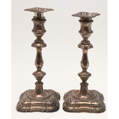 153 - A PAIR OF EDWARDIAN SILVER CANDLESTICKS. with spool-shaped capitals, detachable nozzles, knopped ste... 