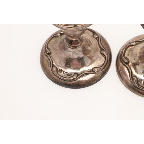 153 - A PAIR OF EDWARDIAN SILVER CANDLESTICKS. with spool-shaped capitals, detachable nozzles, knopped ste... 