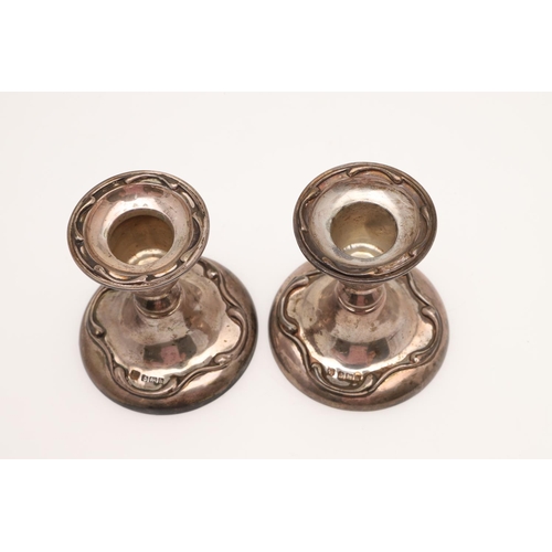 153 - A PAIR OF EDWARDIAN SILVER CANDLESTICKS. with spool-shaped capitals, detachable nozzles, knopped ste... 