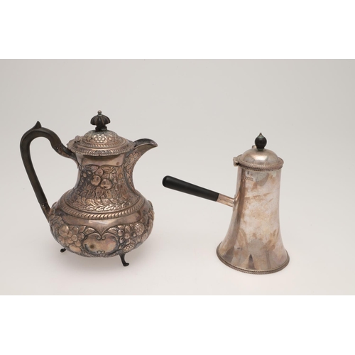 158 - AN EDWARDIAN SILVER HOT WATER JUG. circular form, with a scroll handle and the whole profusely embos... 