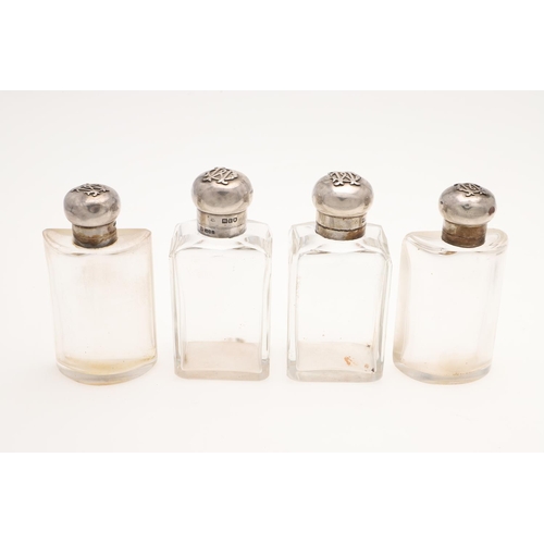 178 - AN EDWARDIAN SCENT/ TOILET WATER SET. with four silver mounted cut-glass bottles, each with applied ... 