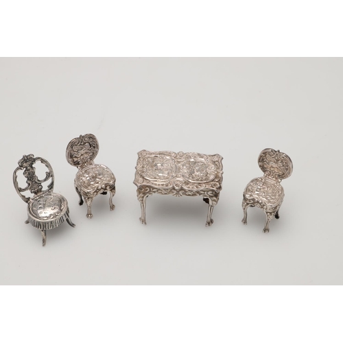 192 - SILVER MINIATURES OR TOYS. 5 chairs, 2 tables, a matched three-piece tea set, a bookcase, a candlest... 