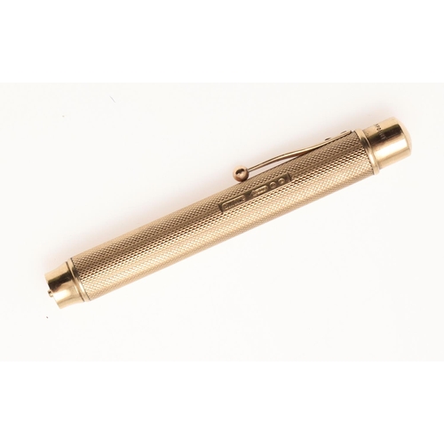 218 - A GEORGE V 9CT. GOLD PROPELLING PENCIL. with a cylindrical body, engine-turned decoration and a butt... 