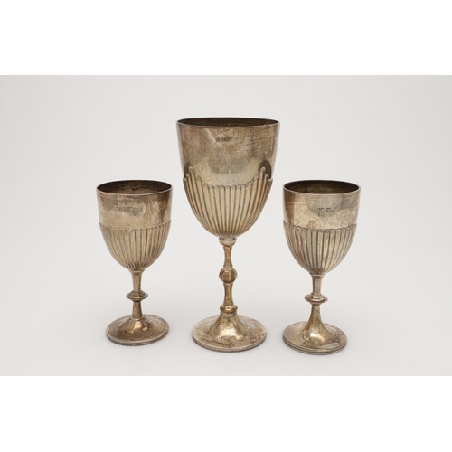 66 - THREE EDWARDIAN SILVER TROPHY GOBLETS. with knopped stems and with part-fluted decoration, a pair by... 