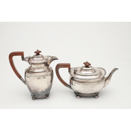 68 - A GEORGE V FOUR-PIECE SILVER TEA SET. with oblong bodies, husk & scroll corners, and raised on bun f... 