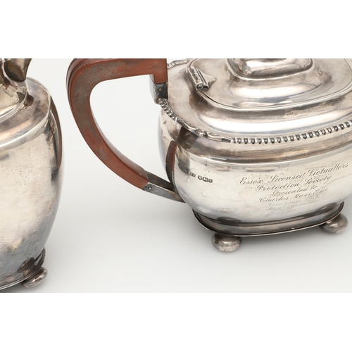 68 - A GEORGE V FOUR-PIECE SILVER TEA SET. with oblong bodies, husk & scroll corners, and raised on bun f... 