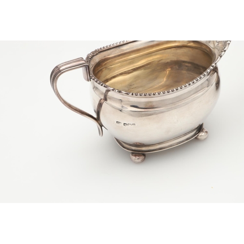 68 - A GEORGE V FOUR-PIECE SILVER TEA SET. with oblong bodies, husk & scroll corners, and raised on bun f... 