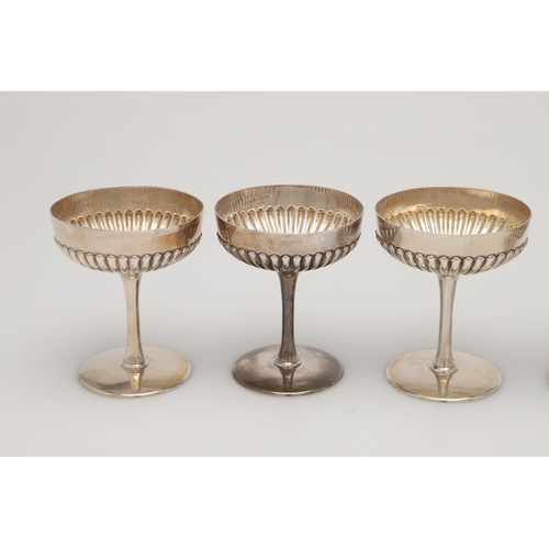 70 - A CASED SET OF SIX LATE VICTORIAN SILVER CHAMPAGNE GOBLETS. the lower halves of the bowls with embos... 