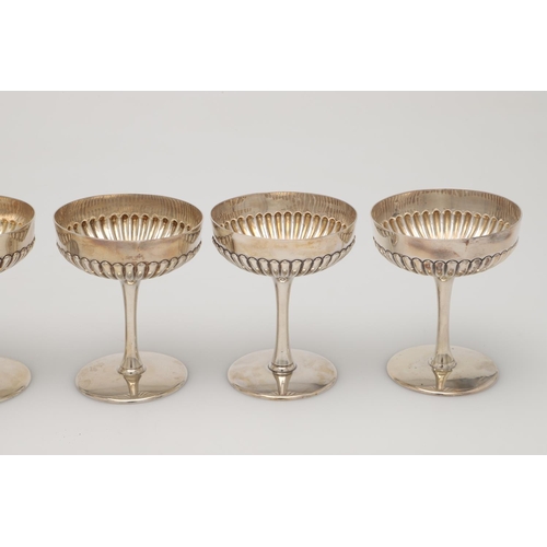 70 - A CASED SET OF SIX LATE VICTORIAN SILVER CHAMPAGNE GOBLETS. the lower halves of the bowls with embos... 