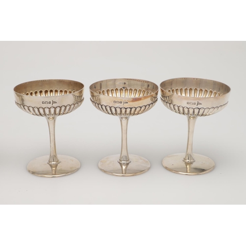 70 - A CASED SET OF SIX LATE VICTORIAN SILVER CHAMPAGNE GOBLETS. the lower halves of the bowls with embos... 