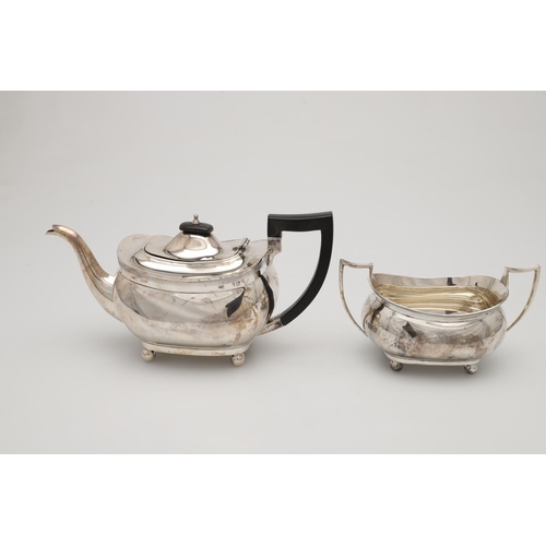 71 - A GEORGE V THREE-PIECE SILVER TEA SET. with rounded oblong bodies, reeded borders and on ball feet, ... 