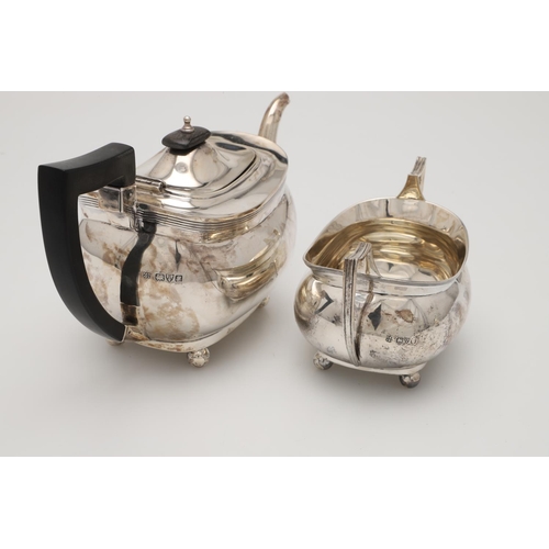 71 - A GEORGE V THREE-PIECE SILVER TEA SET. with rounded oblong bodies, reeded borders and on ball feet, ... 