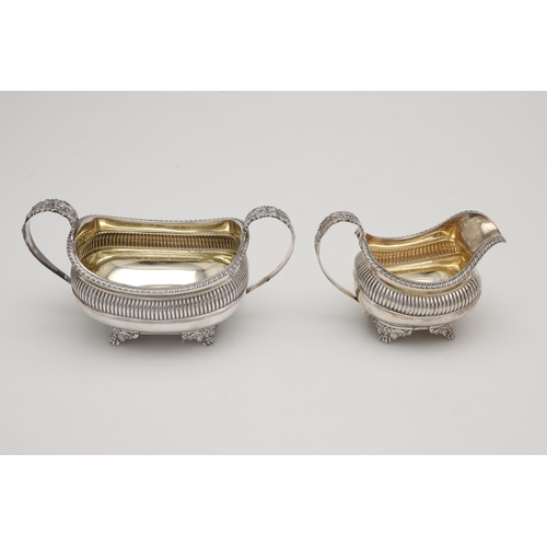 74 - A GEORGE IV THREE-PIECE SILVER TEA SET. with rounded oblong bodies, gadrooned borders,  fluted decor... 