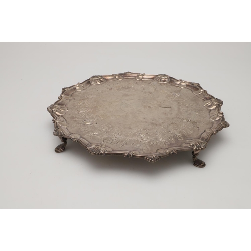 76 - A GEORGE III SILVER SALVER. shaped circular outline,  with a husk & scroll border and later chased &... 