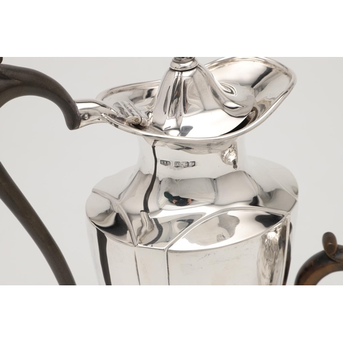 79 - A LATE VICTORIAN SMALL SILVER TEA POT. with an oviform body, embossed & chased decoration, a wooden ... 