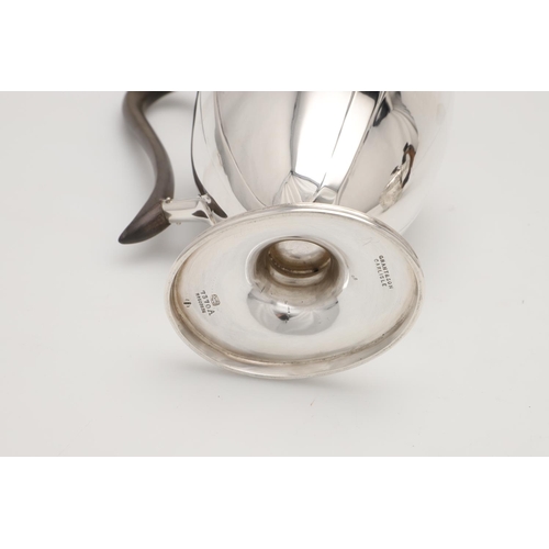 79 - A LATE VICTORIAN SMALL SILVER TEA POT. with an oviform body, embossed & chased decoration, a wooden ... 