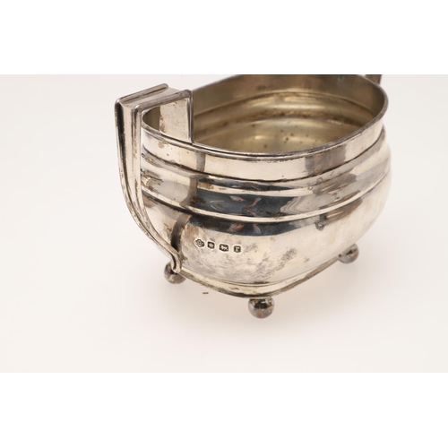 94 - A GEORGE V SILVER TEA POT & MATCHING SUGAR BASIN. rounded rectangular form, with angular handles and... 