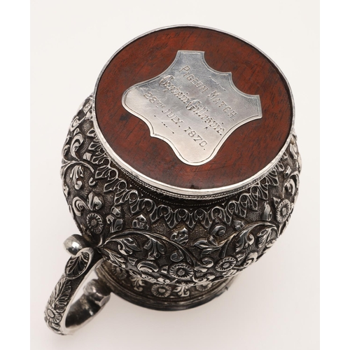 99 - A LATE 19TH CENTURY INDIAN SILVER MUG. of baluster form, profusely chased & embossed with foliage an... 