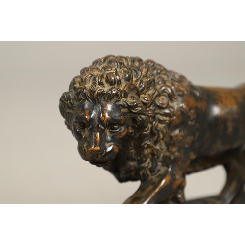 882 - A GRAND TOUR BRONZE OF THE MEDICI LION. 18th/19th century, well worn brown patina, upon later ebonis... 