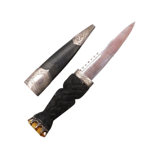139 - A SCOTTISH SILVER MOUNTED SGIAN-DUBH. With a 9 cm Stainless Steel blade on a carved interlaced grip ... 