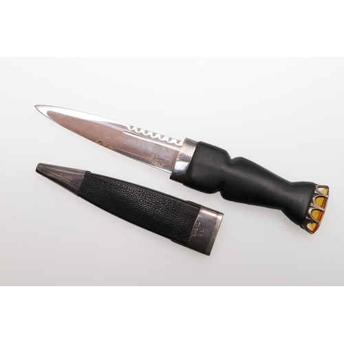 139 - A SCOTTISH SILVER MOUNTED SGIAN-DUBH. With a 9 cm Stainless Steel blade on a carved interlaced grip ... 