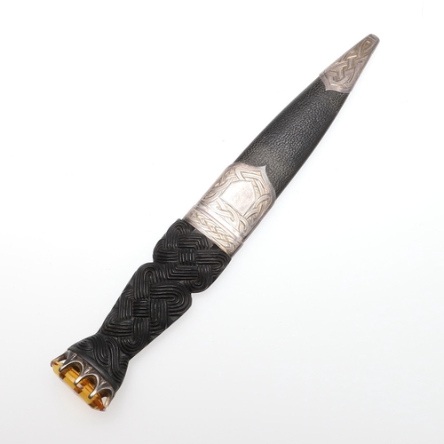 139 - A SCOTTISH SILVER MOUNTED SGIAN-DUBH. With a 9 cm Stainless Steel blade on a carved interlaced grip ... 
