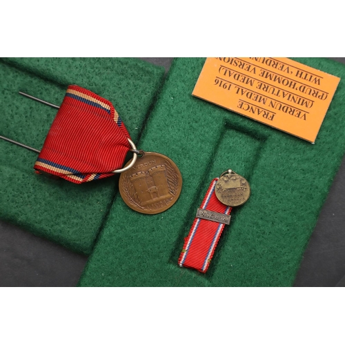 1083 - FRANCE: FOUR MEDALS FOR VERDUN. A Verdun medal with 'Verdun 21 Fevrier 1916' clasp and sewn four lea... 