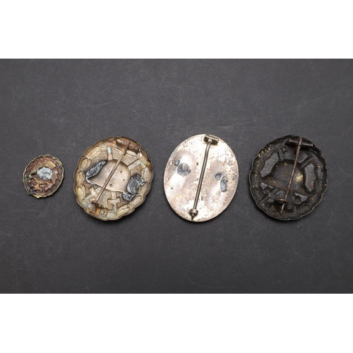 1142 - GERMANY: A COLLECTION OF FOUR GERMAN WOUND BADGES. Four German Wound badges, one bronze and two 'sil... 