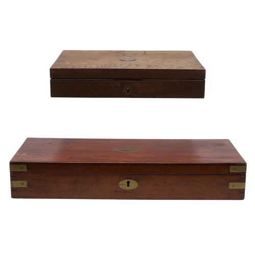 62 - TWO PISTOL BOXES, BOTH WITH VACANT INTERIORS. An oak pistol box, rectangular with a central brass di... 
