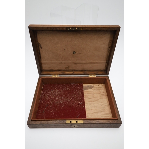 62 - TWO PISTOL BOXES, BOTH WITH VACANT INTERIORS. An oak pistol box, rectangular with a central brass di... 
