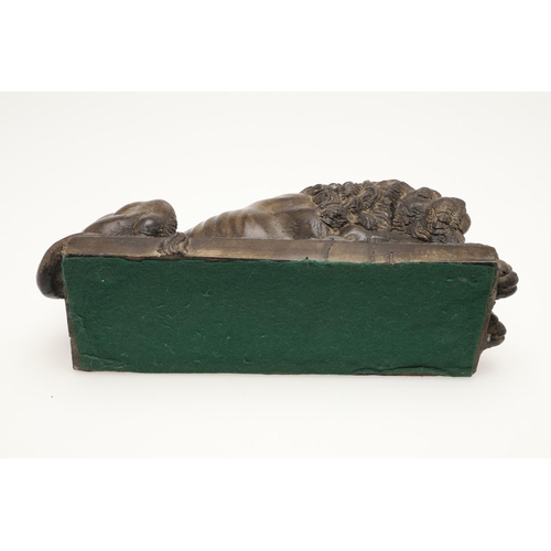 419 - A 20TH CENTURY SCULPTURE OF A RECUMBENT LION. with bronze effect finish, upon a rectangular base, un... 