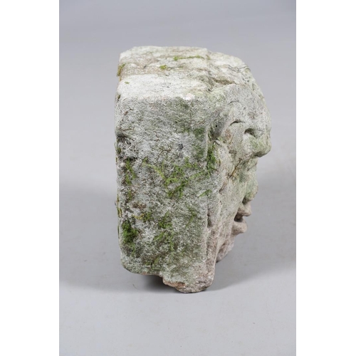 445 - A MEDIEVAL CARVED STONE CORBEL. depicting a grotesque, approx. 30cm high, 25cm wide x 24cm deep.