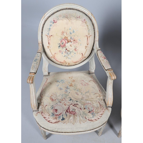 456 - A PAIR OF FRENCH PAINTED BEECH OPEN ARMCHAIRS. early 20th century, with brass studded floral tapestr... 