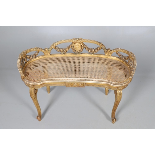 457 - A LATE 19TH CENTURY FRENCH GILTWOOD AND CANE WINDOW SEAT. the back with carved floral swags and bow ... 