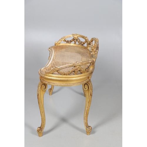 457 - A LATE 19TH CENTURY FRENCH GILTWOOD AND CANE WINDOW SEAT. the back with carved floral swags and bow ... 