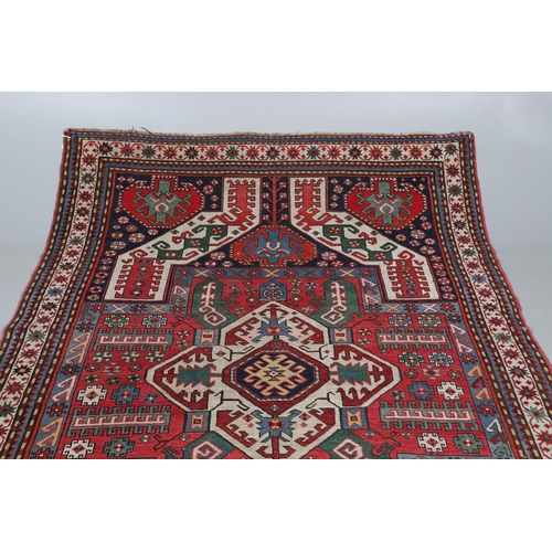 505 - A KASIM USHAG RUG, SOUTH CAUCASUS, CIRCA 1910. the madder central panel with an ivory and indigo med... 