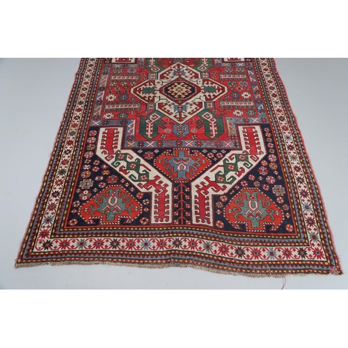 505 - A KASIM USHAG RUG, SOUTH CAUCASUS, CIRCA 1910. the madder central panel with an ivory and indigo med... 