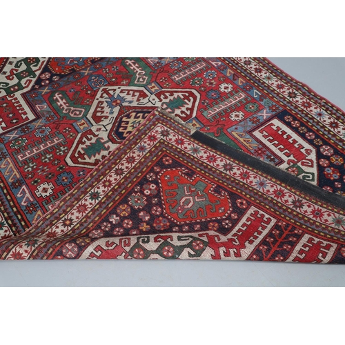 505 - A KASIM USHAG RUG, SOUTH CAUCASUS, CIRCA 1910. the madder central panel with an ivory and indigo med... 