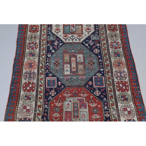 509 - A CAUCASIAN RUNNER, CIRCA 1900. the indigo field with a column of octagons containing stylised plant... 