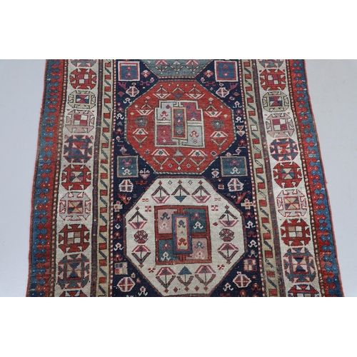 509 - A CAUCASIAN RUNNER, CIRCA 1900. the indigo field with a column of octagons containing stylised plant... 