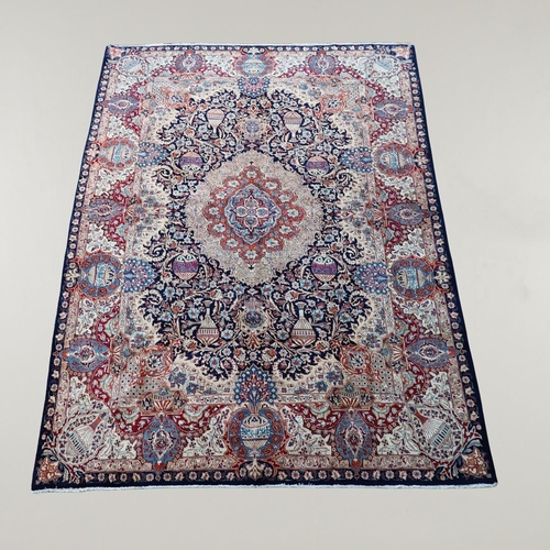 513 - A KASHMIR CARPET. the midnight blue field with vines and ears around a medallion framed by borders o... 