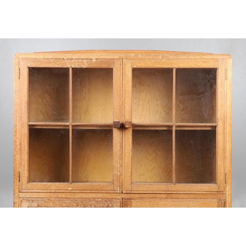 556 - BRYNMAWR FURNITURE - OAK DISPLAY CABINET. An oak display cabinet with a glazed top section with a si... 