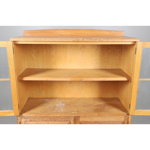 556 - BRYNMAWR FURNITURE - OAK DISPLAY CABINET. An oak display cabinet with a glazed top section with a si... 