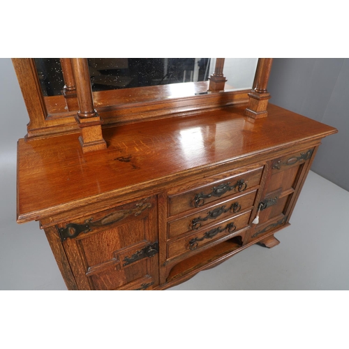 557 - ARTS & CRAFTS OAK MIRROR BACK SIDEBOARD. A large Arts & Crafts oak sideboard with a mirror back, the... 