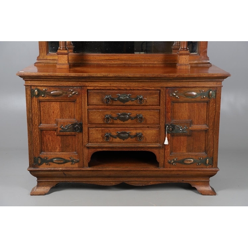 557 - ARTS & CRAFTS OAK MIRROR BACK SIDEBOARD. A large Arts & Crafts oak sideboard with a mirror back, the... 