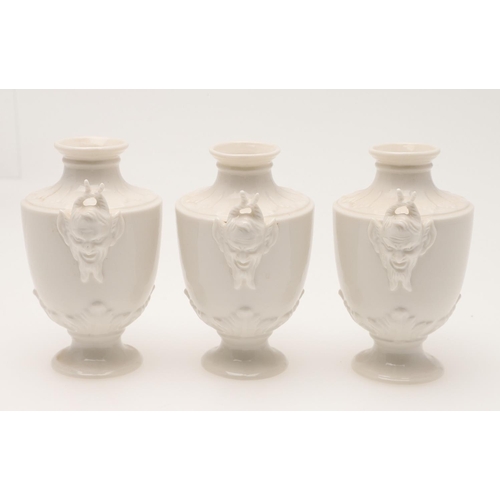 593 - NYPHENBURG - SET OF SATYR MINIATURE URNS. A set of 8 miniature urns in the white, of tapering shape ... 