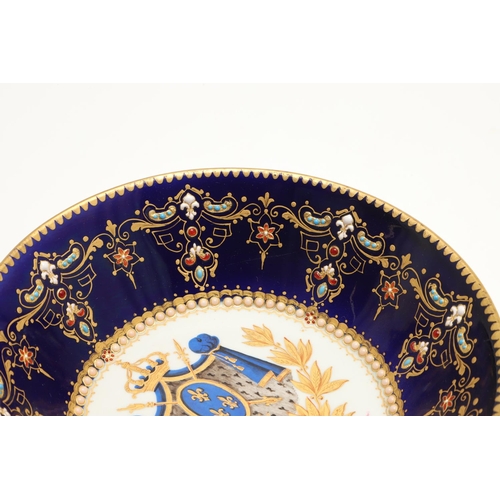 600 - A SEVRES STYLE BLUE GROUND JEWELLED CABINET CUP AND SAUCER. late 19th century, the cup painted with ... 