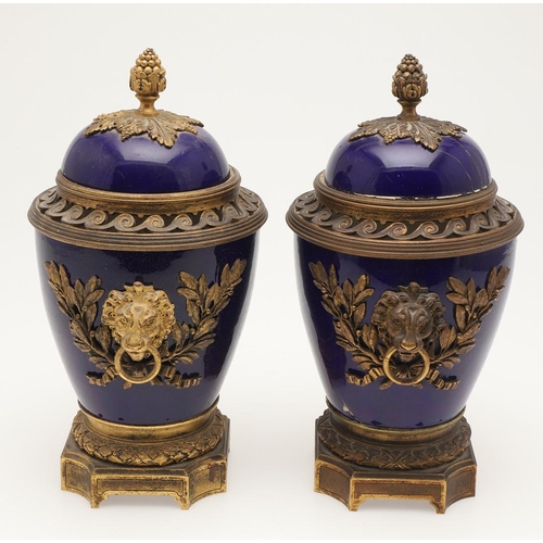 610 - PAIR OF SEVRES STYLE LIDDED PORCELAIN URNS. A pair of porcelain and gilded metal mounted urns,  with... 